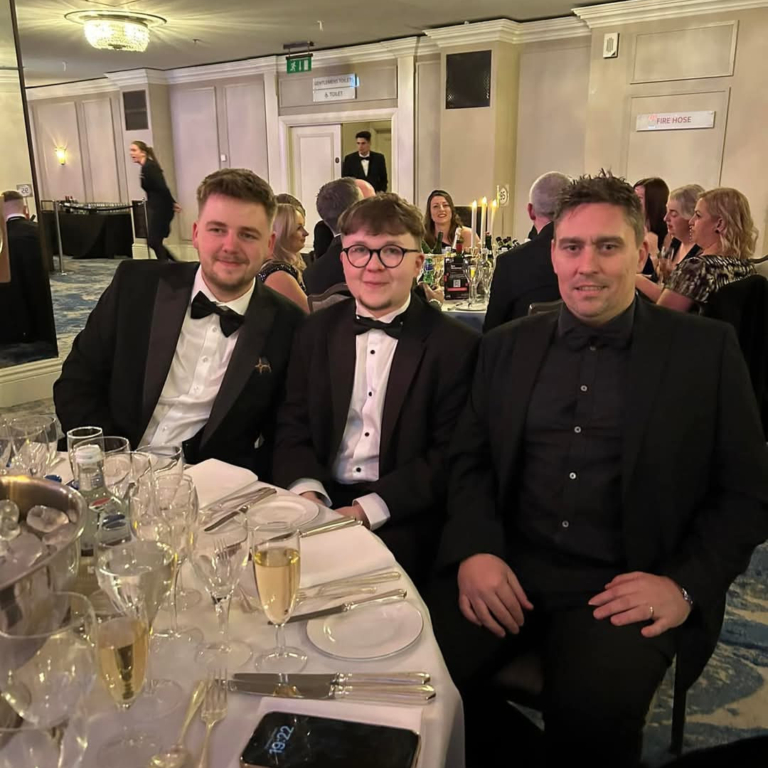 GLP Training Ranked 5th Best Place to Work in the UK - this is 3 members of the team in formal wear posing at their table at the ceremony event.