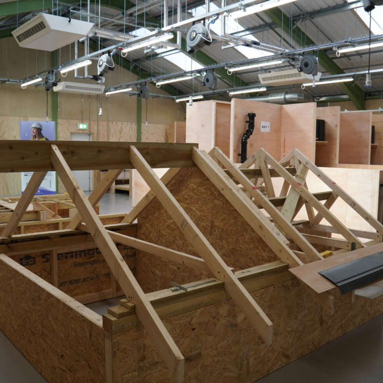 Inside Building Block Two - a stand where learners can work on a roof structure during their training