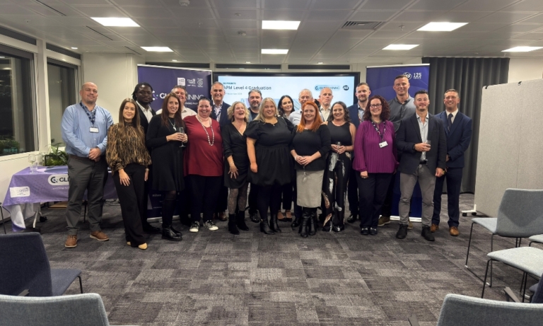 GLP Training tutors with ISS Employees, who had successfully completed their Level 4 APM Apprenticeship, on their graduation day. Group picture. Office setting.