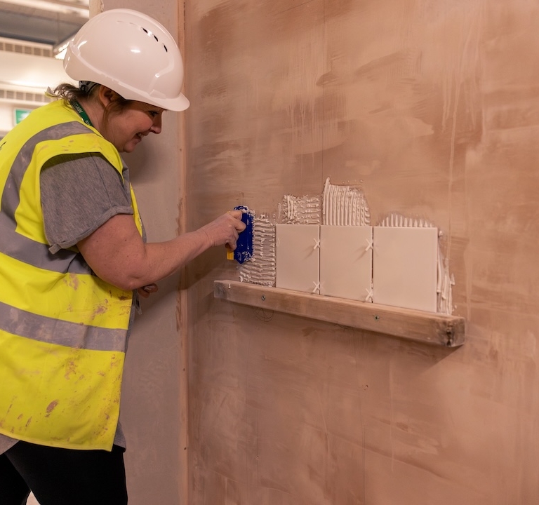 A learner tiling a wall