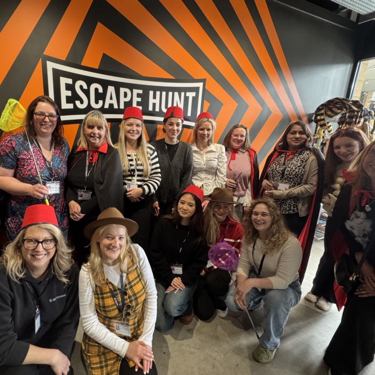 Women from GLP Training standing together for a group photo in front of the Escape Hunt Sign.